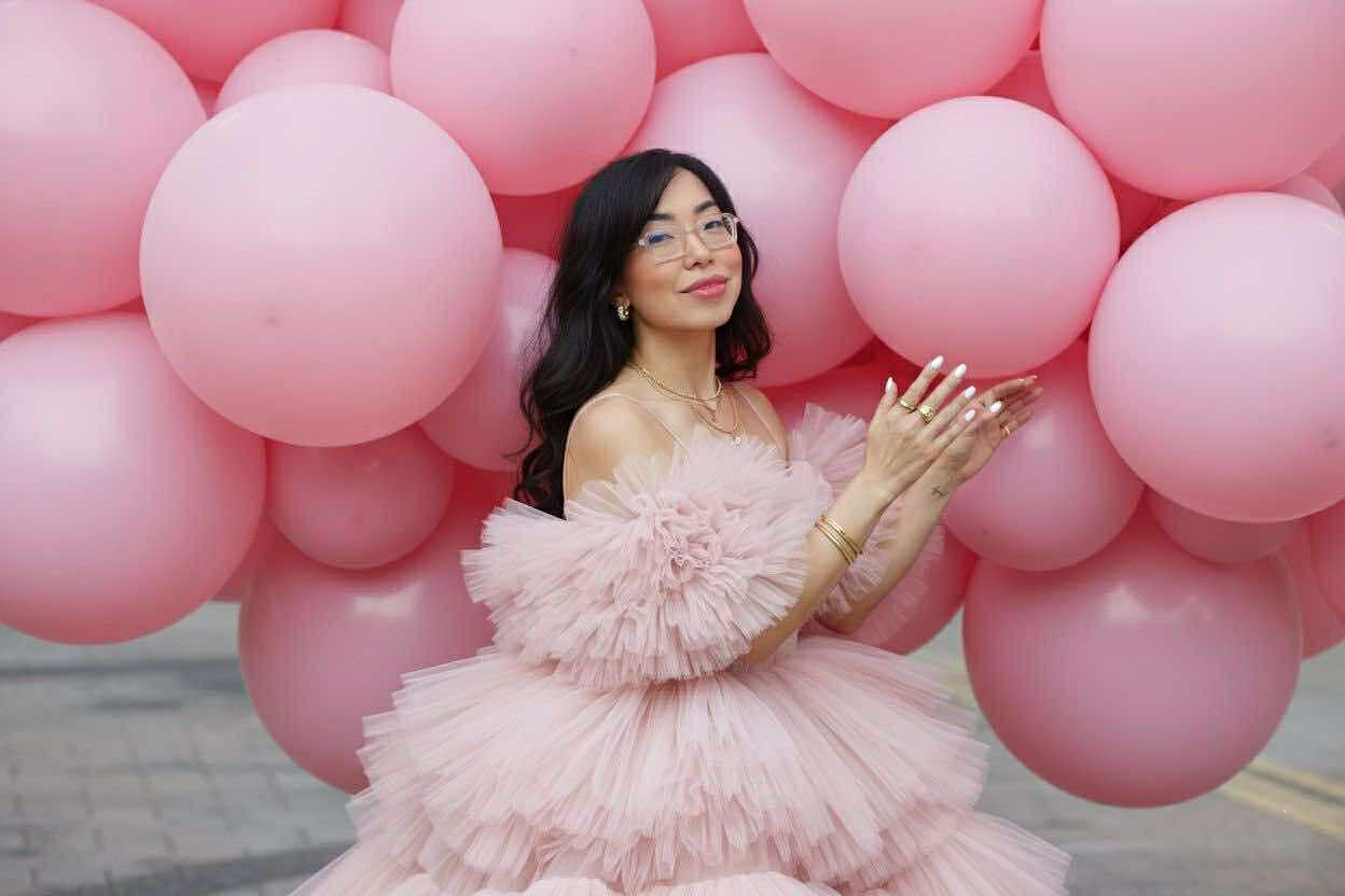 Angela Ricardo the digital bestie influencer, posing with hundreds of pink large balloons